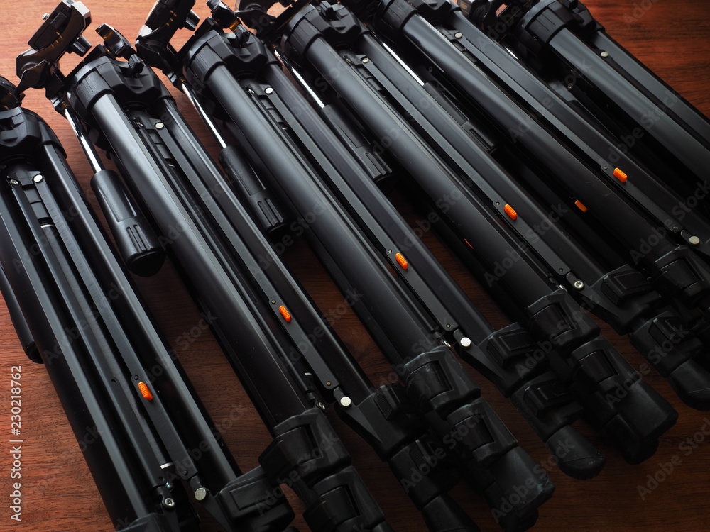 Many camera tripods ready for filming or photo session. Photography or filming equipment. Many camera tripods ready for filming or photo session. Photography or filming equipment.