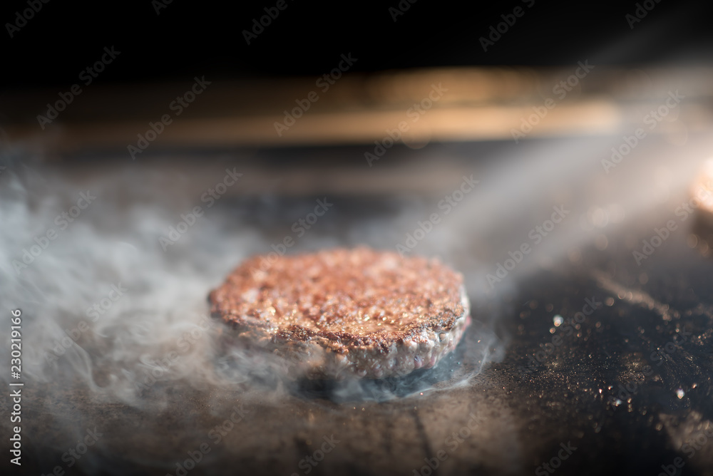 Fresh meat cutlets in a frying pan grill. A lot of steam or smoke