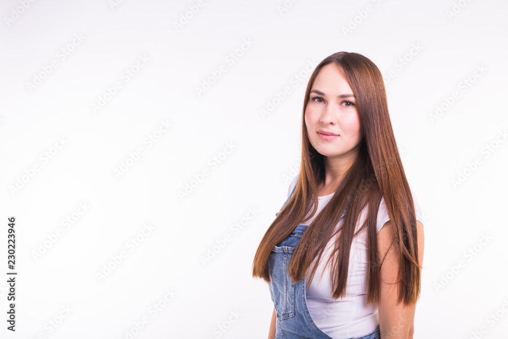 Portrait of a smiling pretty woman in denim overall isolated on white background with copy space Portrait of a smiling pretty woman in denim overall isolated on white background with copy space