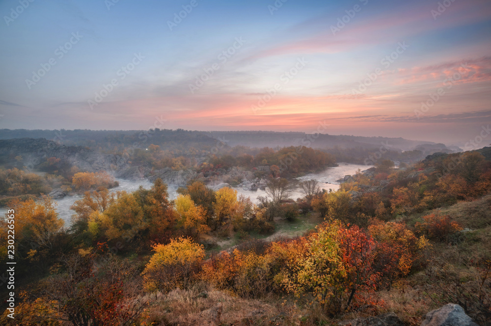 Naklejka premium amazing aerial view of mountain rocks, blue foggy river and colorful forest on sunrise. autumn landscape
