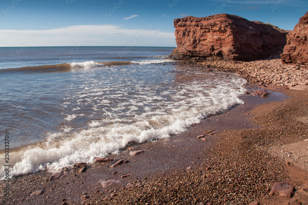 Small waves crashing alone north western shoreline of Prince Edward Island Small waves crashing alone north western shoreline of Prince Edward Island
