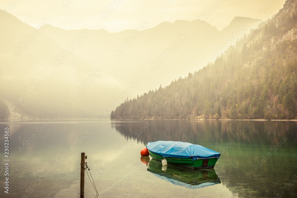 Small boat on lake Plansee in the European Alps, in Austria at early morning sunrise