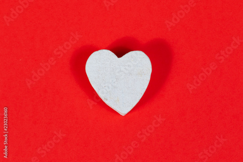 White wooden heart on red background