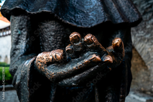 Religious monk pray for alms statue from metal and iron