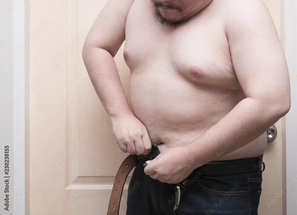 Overweight man trying to fasten too small jean pants. Represent of fat,  obesity, big belly. Stock Photo