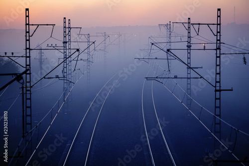 Fototapeta railways & electricity pylons at sunset, industrial landscape