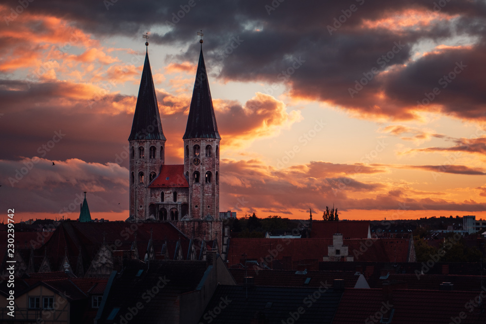 Cityscape panorama view from the historic gothic old town with dome and roof tops. Dramatic clouds and light from sunlight after rainy weather. Moody warm tone . Braunschweig, Lower Saxony in Germany