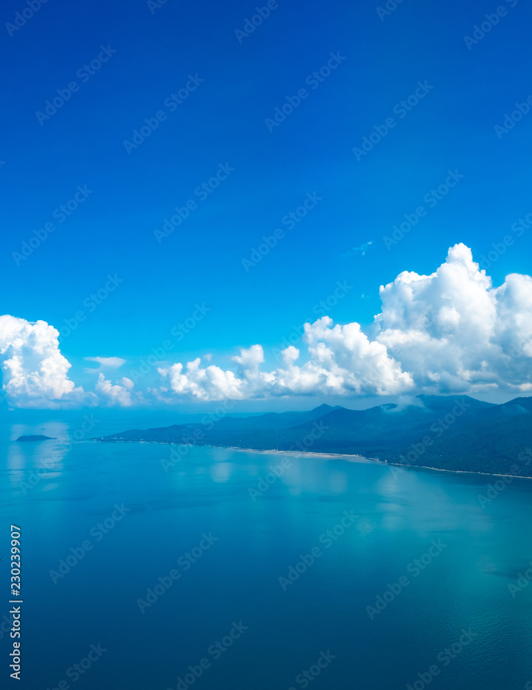 Island and beach under cloudy blue sky