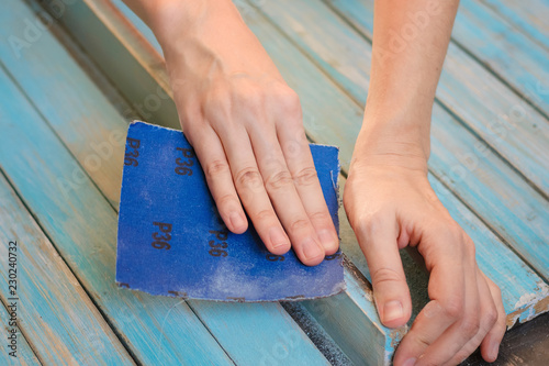 Process of hand polishing wooden board surface with a sandpaper