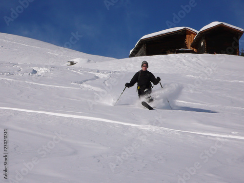 фотографія man teelemark skiing in the Swiss backcountry in deep winter and fresh powder on