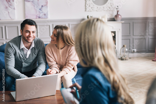 Happy young loving couple sitting together with their financial advisor.