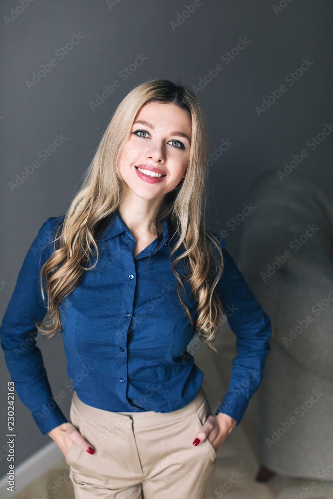 Cheerful businesswoman standing over gray background. Cheerful businesswoman standing over gray background.