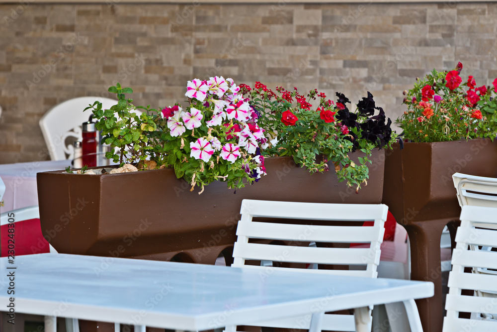 table and chairs and flowers in a restaurant outdoors