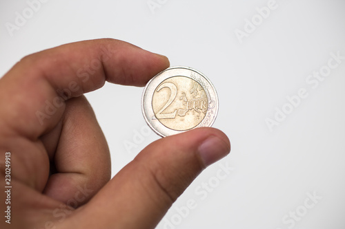 hand holding 2 Euro coins on a white background - Money, Financial, saving, Growth concept
