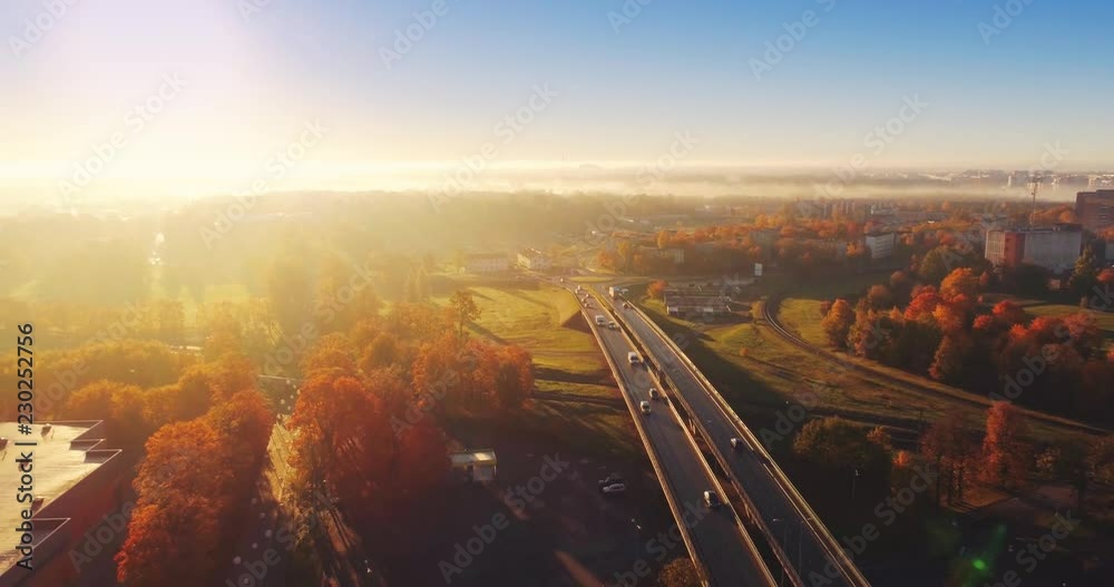 Beautiful Aerial Shot of Misty Sunrise in small town. Colorful clouds, fog above the city.