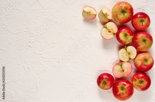 Various fresh red apples on the white concrete background. Top view with copy space for text