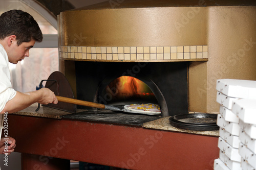 Piekarz wkłada pizzę do pieca.