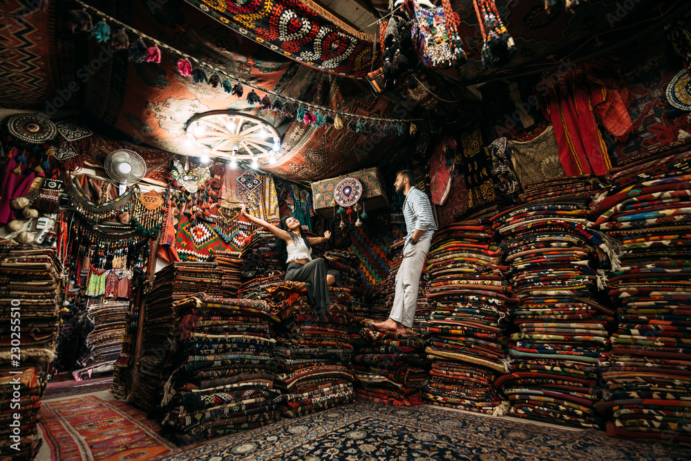 Guy and girl in the store. Couple in love in Turkey. Man and woman in the Eastern country. Gift shop. A couple in love travels. Persian shop. Tourists in store. Oriental carpet. Istanbul. Emirates