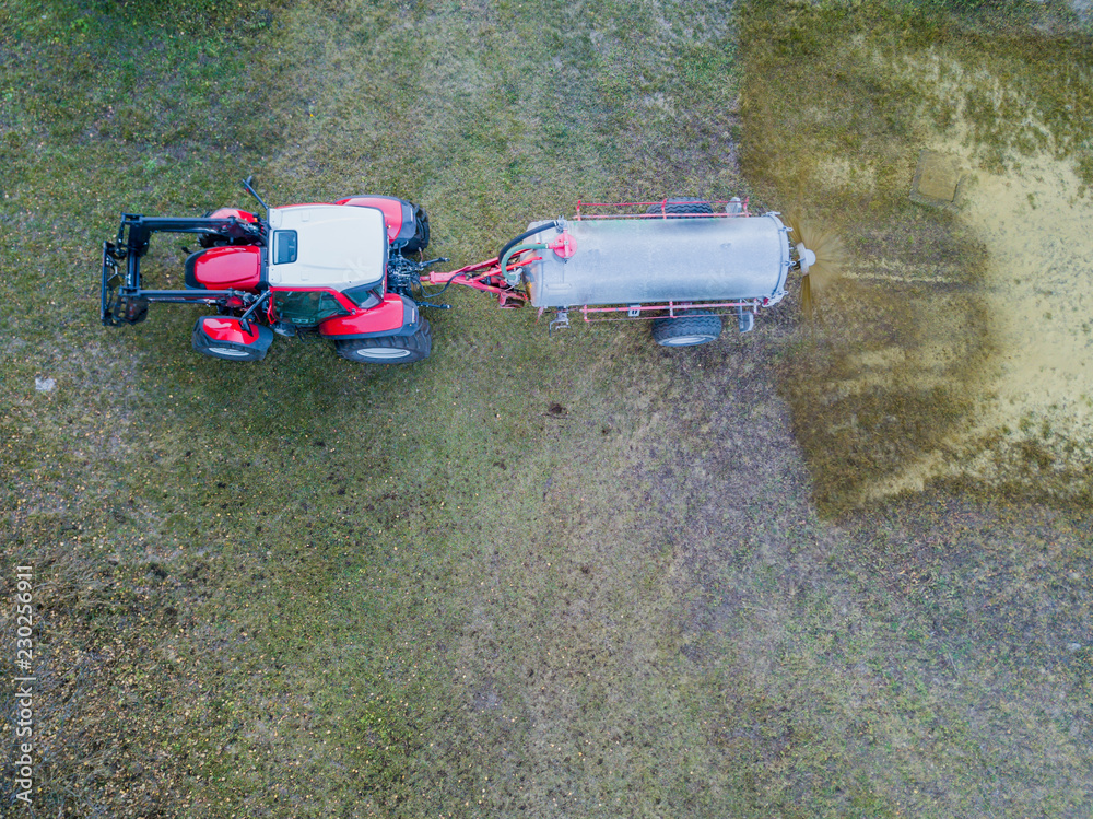 Aerial view of tractor spraying liquid manure on agricultural field Aerial view of tractor spraying liquid manure on agricultural field