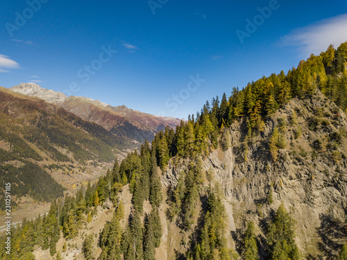 Aerial view of mountain valley in Switzerland in Canton of valais in autumn with blue sky