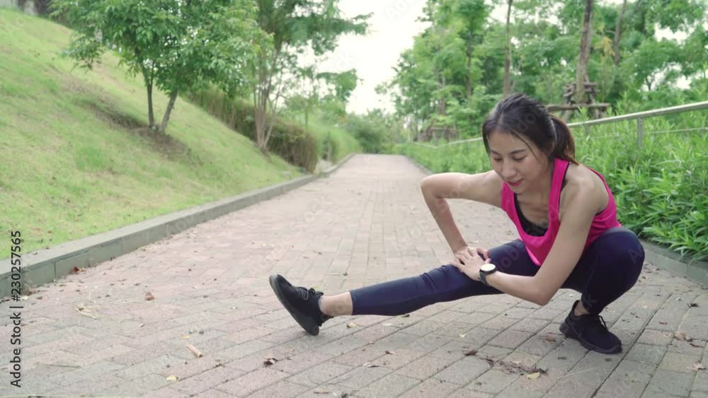 Healthy beautiful young Asian Athlete women in sports clothing legs warming and stretching her arms to ready for running on street in urban city park. Lifestyle active women exercise in city concept. Healthy beautiful young Asian Athlete women in sports clothing legs warming and stretching her arms to ready for running on street in urban city park. Lifestyle active women exercise in city concept.