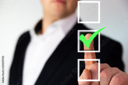 Businessman pushing checkbox button with a green tick. 