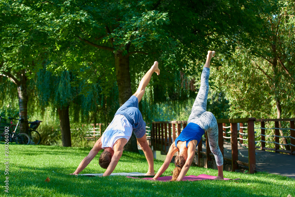 Couple doing yoga exercises together outdoor