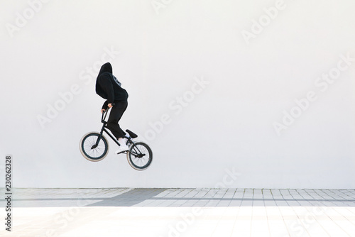 BMX freestyle. Young BMX bicycle makes tricks on the white background. Copyspace. Bmx trick on a white background