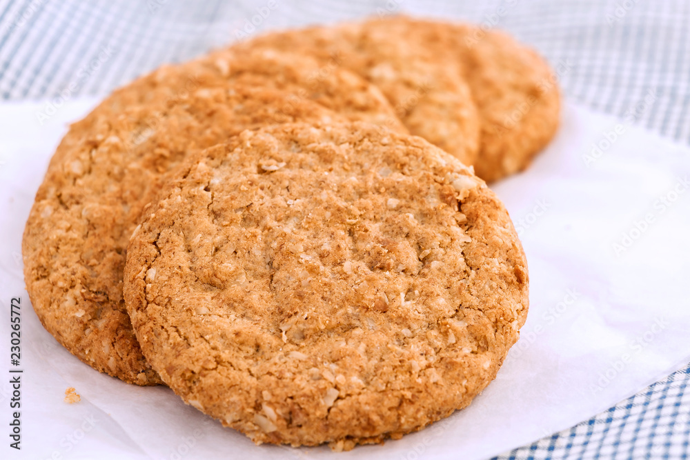 Homemade shortbread cookies made of oatmeal are stacked on white paper on the cloth background. Concept food healthy snack for enjoy in holiday. Homemade shortbread cookies made of oatmeal are stacked on white paper on the cloth background. Concept food healthy snack for enjoy in holiday.