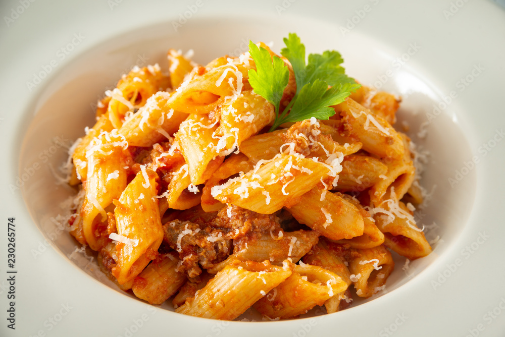 Piatto di mezze penne con ragù alla bolognese e formaggio grattugiato Piatto di mezze penne con ragù alla bolognese e formaggio grattugiato