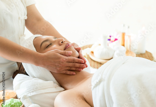 Beautiful woman lying in spa salon, women enjoying face massage, Health care concept.