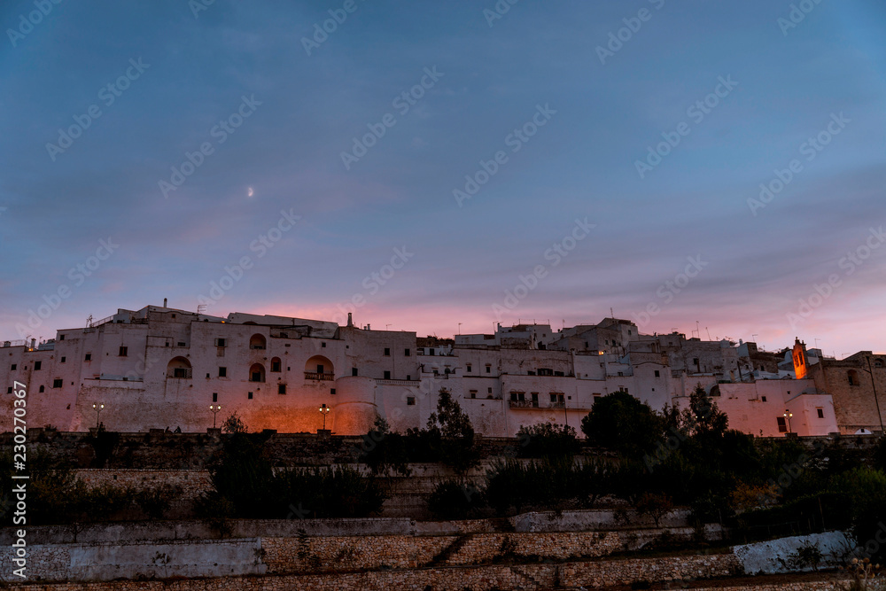 Panoramic view of the medieval white village of Ostuni at sunset golden hour