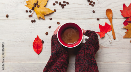 Manos cogiendo una taza de cafe caliente en otoño photo