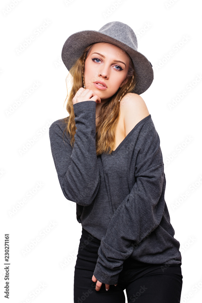 Beautiful young woman in casual gray outfit and hat, posing. Medium retouched, studio lighting, isolated on white background. Beautiful young woman in casual gray outfit and hat, posing. Medium retouched, studio lighting, isolated on white background.