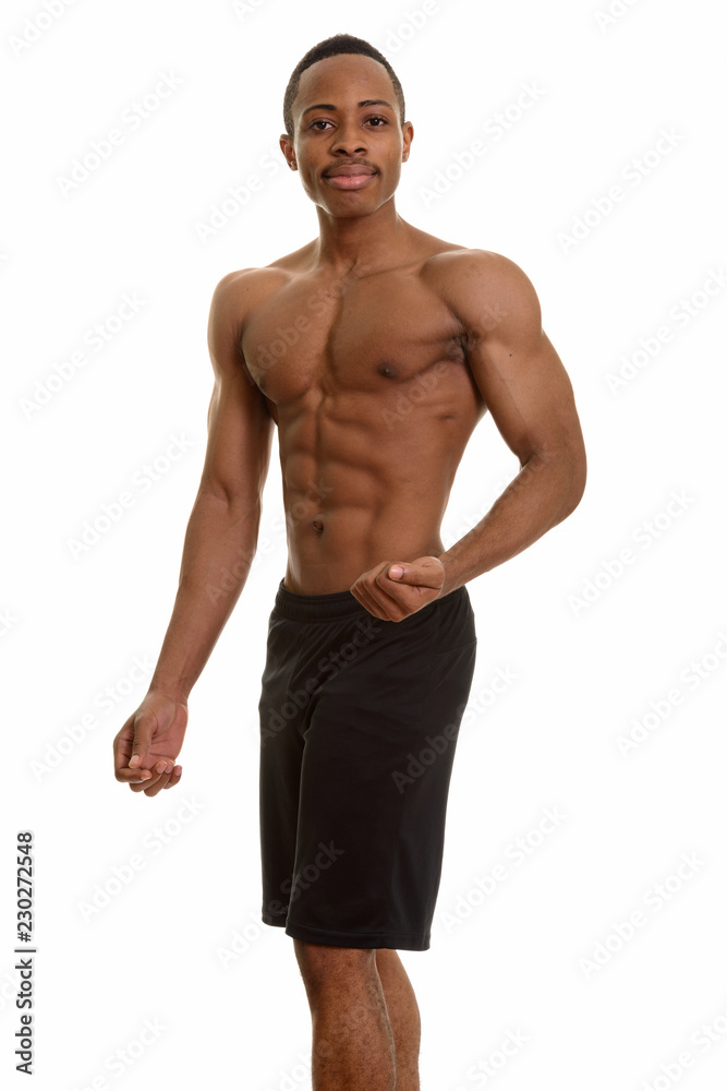 Young handsome African man shirtless flexing left arm Young handsome African man shirtless flexing left arm