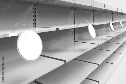 Photography Empty racks with shelves in a supermarket with round wobblers in perspective