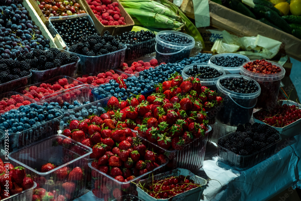 fresh summer berries on the counter, strawberries, raspberries, blackberries, blueberries.