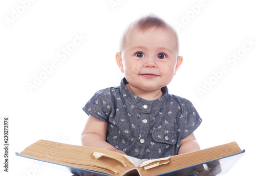 Baby girl with book sitting on white background photo