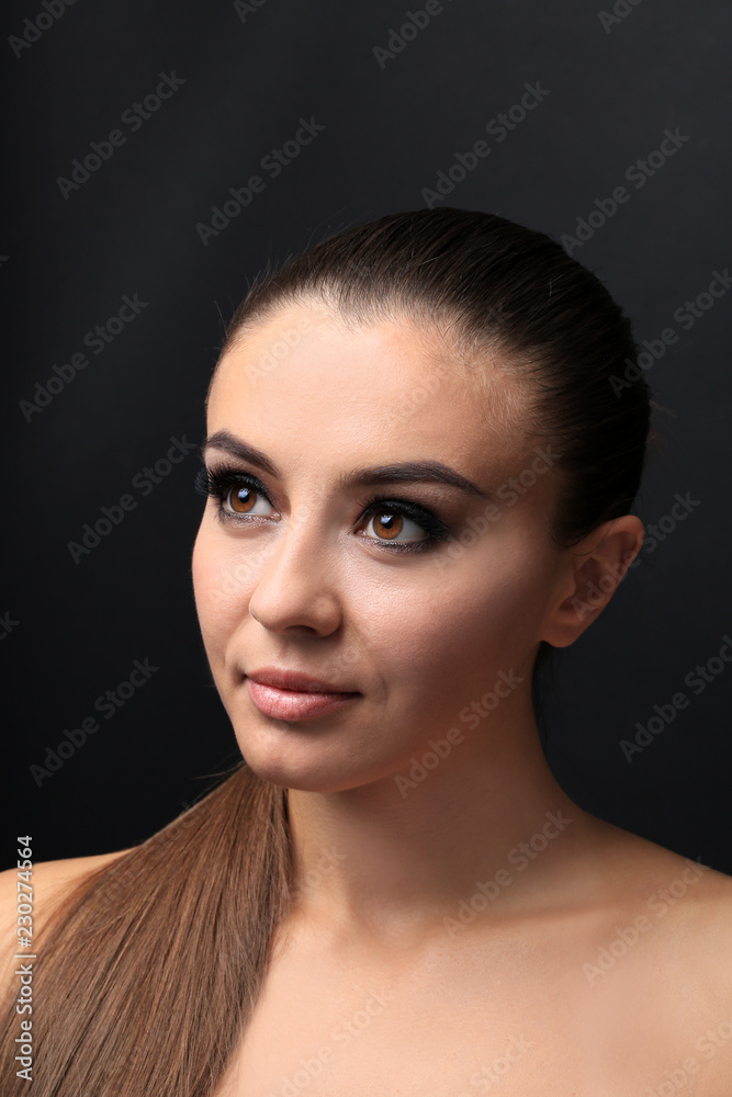 Beautiful young woman with eyelash extensions on dark background Beautiful young woman with eyelash extensions on dark background