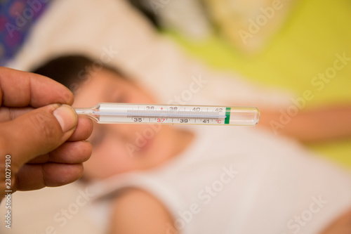 horizontal image with detail of a hand holding a thermometer to see the temperature