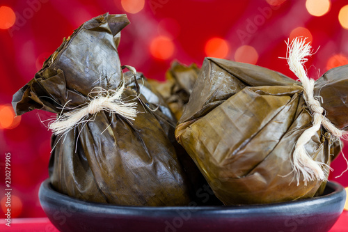 Traditional Colombian tamale as made on Tolima region over a christmas red background photo