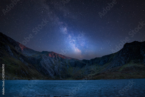 Digital composite Milky Way image of Beautiful landscape image of Llyn Idwal and Devil's Kitchen in Snowdoina