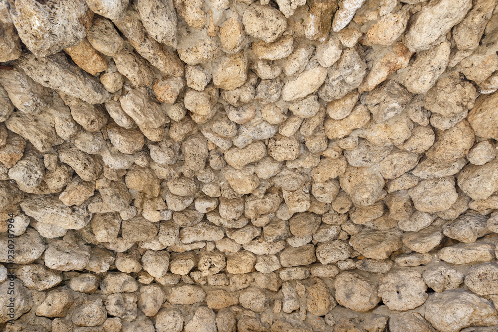 Ancient wall made of round stones as a background or backdrop Ancient wall made of round stones as a background or backdrop