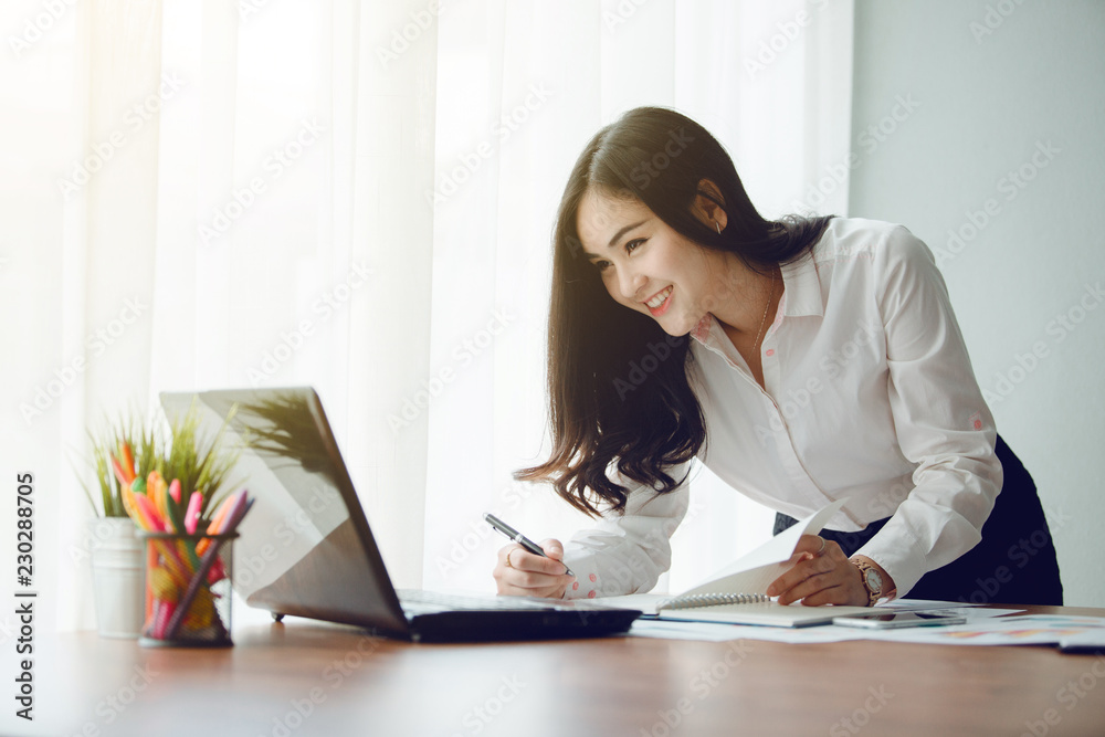 Beautiful young woman working on her laptop in her office.