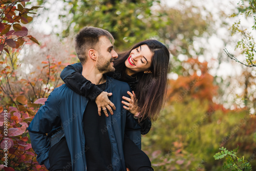 Happy young couple walk in autumn forest