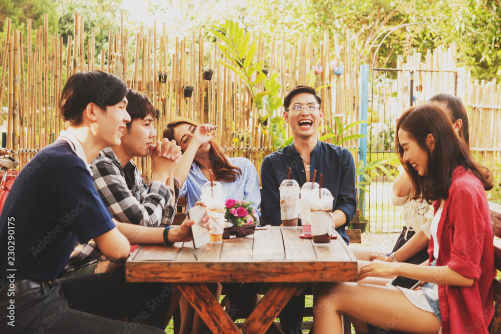 Group of six teenagers having fun together in coffee shop on the afternoon
