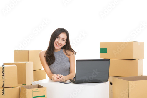 Young woman freelancer working and checklist and writing order with cardboard box on white background - SME business online and delivery concept © uinmine