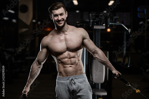 sexy strong bodybuilder athletic men pumping up muscles with dumbbells