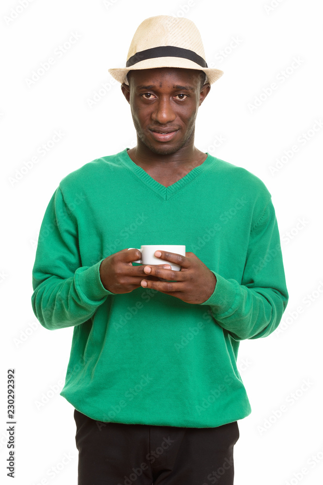 Young happy African man smiling and holding coffee cup Young happy African man smiling and holding coffee cup