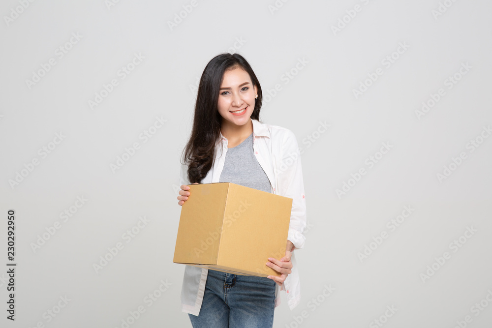Delivery, relocation and unpacking. Smiling young woman holding cardboard box isolated Delivery, relocation and unpacking. Smiling young woman holding cardboard box isolated